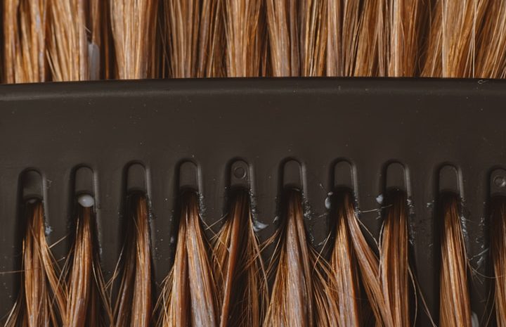 Haarsprechstunde Heidelberg – Diagnose und Therapie bei Haarausfall in der ATOS Dermatologie Nahaufnahme von Haaren in einer Bürste - Haarsprechstunde in der ATOS Dermatologie Heidelberg zur Diagnose und Behandlung von Haarausfall